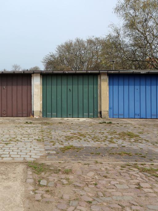 Ein Garagenhof aus DDR-Zeiten mit unterschiedlich farbigen Metalltoren