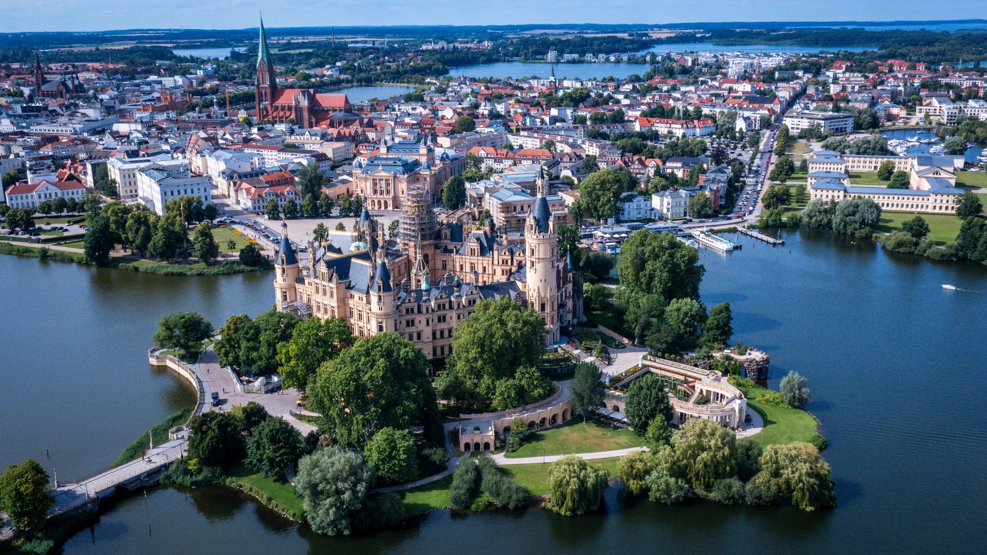 Das Schloss auf einer Insel im Schweriner See war jahrhundertelang die Residenz der mecklenburgischen Herzöge und Großherzöge und ist heute Sitz des Landtages von Mecklenburg-Vorpommern. (Luftaufnahme mit einer Drohne). Es ist ab sofort UNESCO-Welterbe