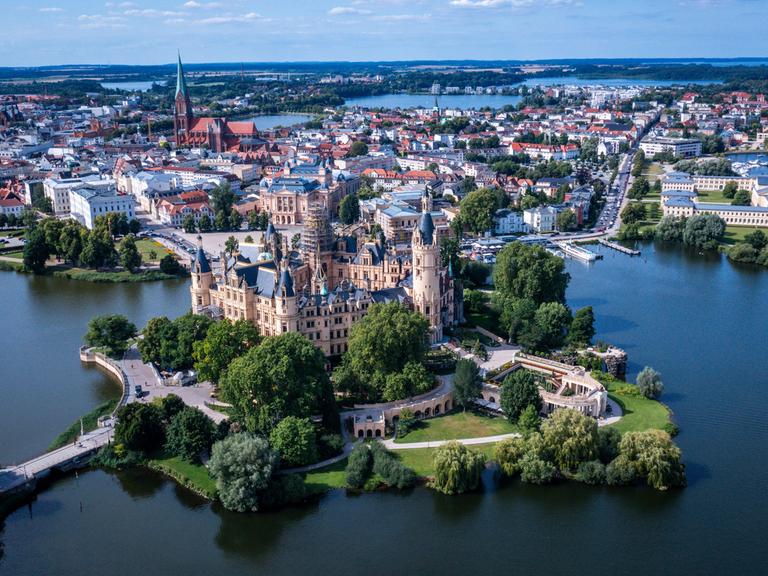 Das Schloss auf einer Insel im Schweriner See war jahrhundertelang die Residenz der mecklenburgischen Herzöge und Großherzöge und ist heute Sitz des Landtages von Mecklenburg-Vorpommern. (Luftaufnahme mit einer Drohne). Es ist ab sofort UNESCO-Welterbe