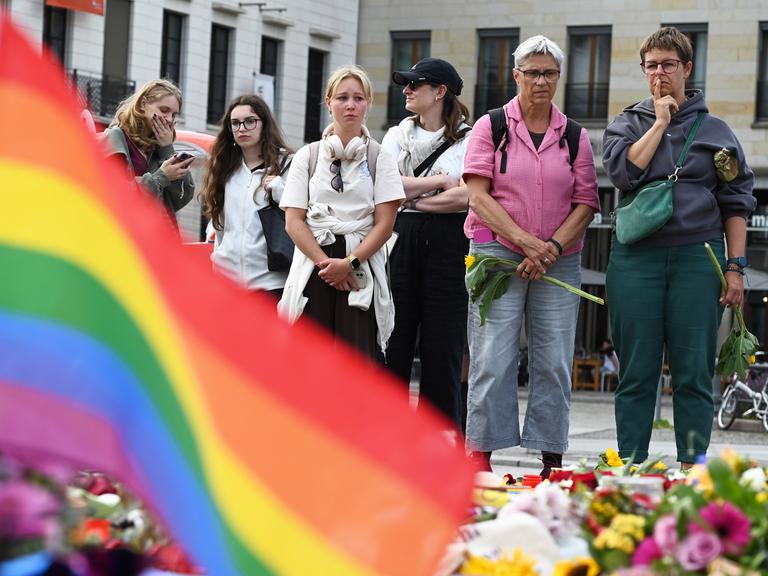 Mahnwache für die Opfer des mutmaßlichen Anschlags beim CSD. Menschen legen Blumen und Kerzen nieder.
