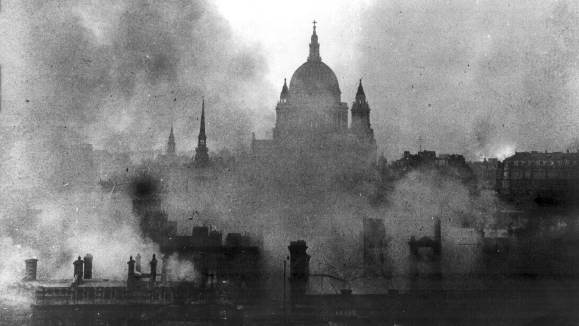 Schwarz-Weiß-Aufnahme zeigt die St Pauls Cathedral in London umgeben von Rauchschwaden.
