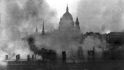 Schwarz-Weiß-Aufnahme zeigt die St Pauls Cathedral in London umgeben von Rauchschwaden.