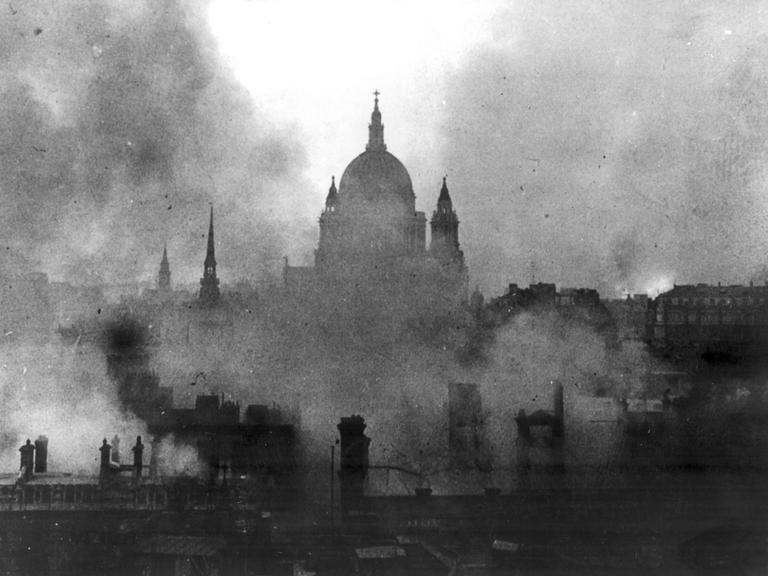 Schwarz-Weiß-Aufnahme zeigt die St Pauls Cathedral in London umgeben von Rauchschwaden.