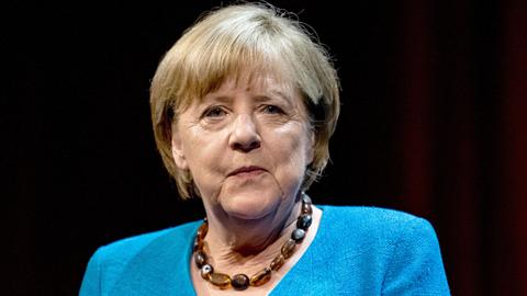 Ds Foto zeigt die ehemalige Bundeskanzlerin Angela Merkel (CDU). Sie trägt einen blauen Blazer und eine Halskette.