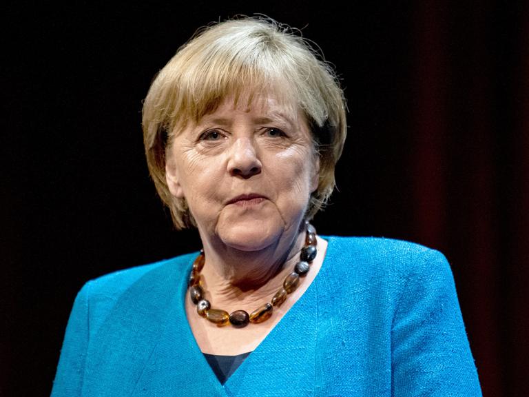 Berlin: Die ehemalige Bundeskanzlerin Angela Merkel (CDU) schaut in die Kamera. Sie hat einen blauen Blazer an und trägt eine Kette.