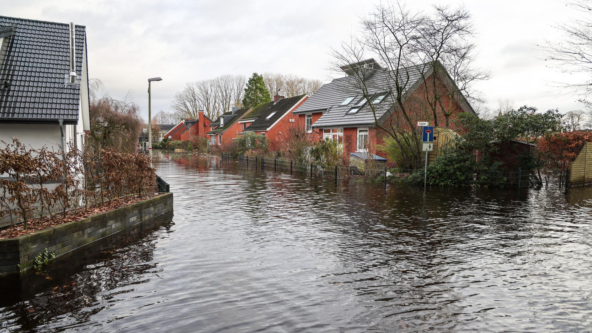 Wohnhäuser stehen in einem überfluteten Ortsbereich an der Wörpe. Durch das Hochwasser des Flusses sowie der nahegelegenen Wümme gab es in der Nacht einen Deichriss.