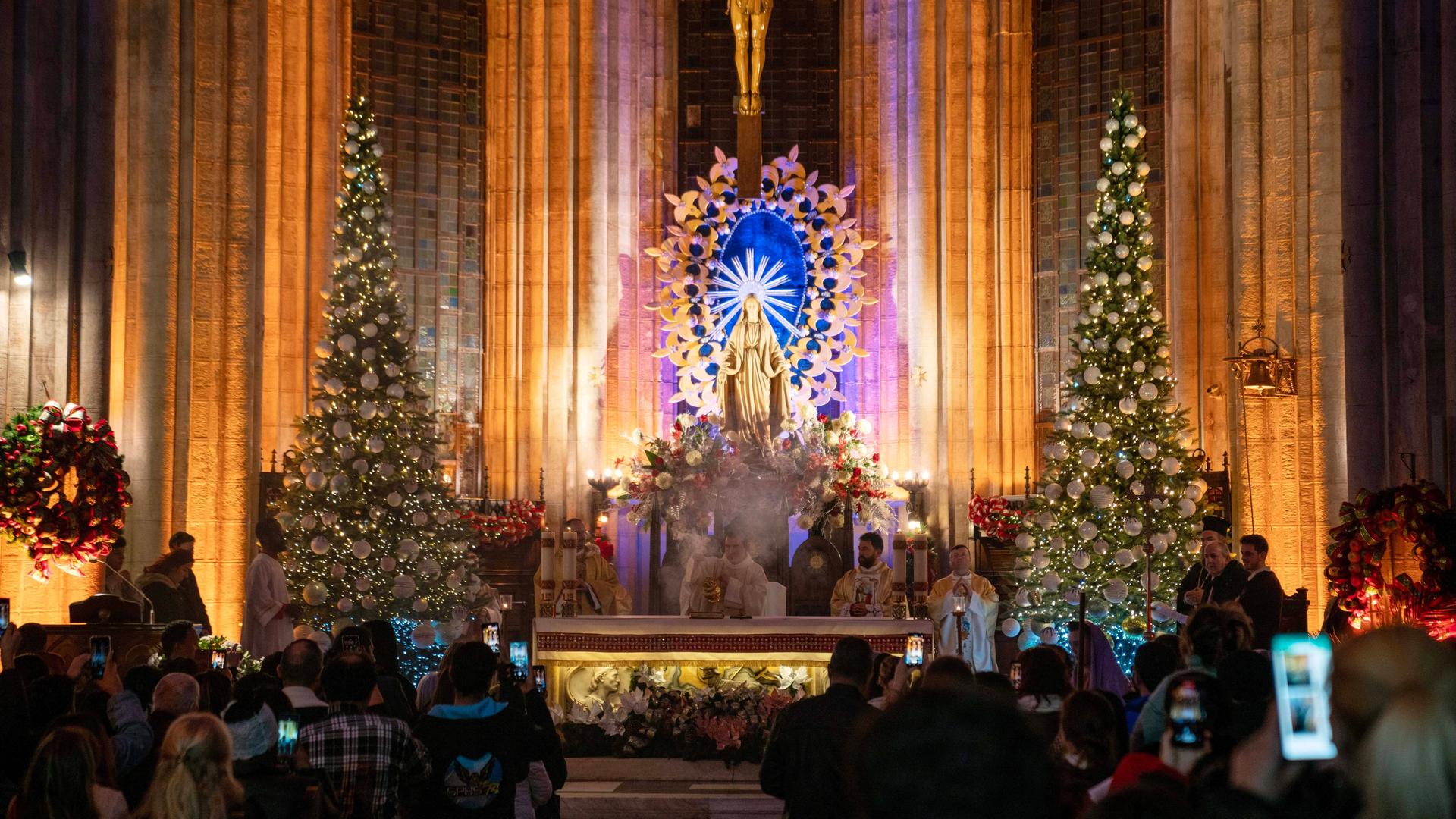 In einer katholischen Kirche wird eine Weihnachtsmesse abgehalten.