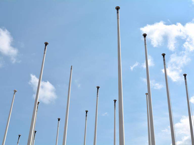 Leere Fahnenmasten vor blauem Himmel (in Berlin)