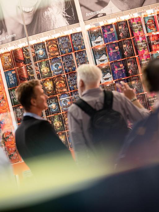 Besucher schauen sich auf der Frankfurter Buchmesse Buchtitel und die Stände der Aussteller an. 