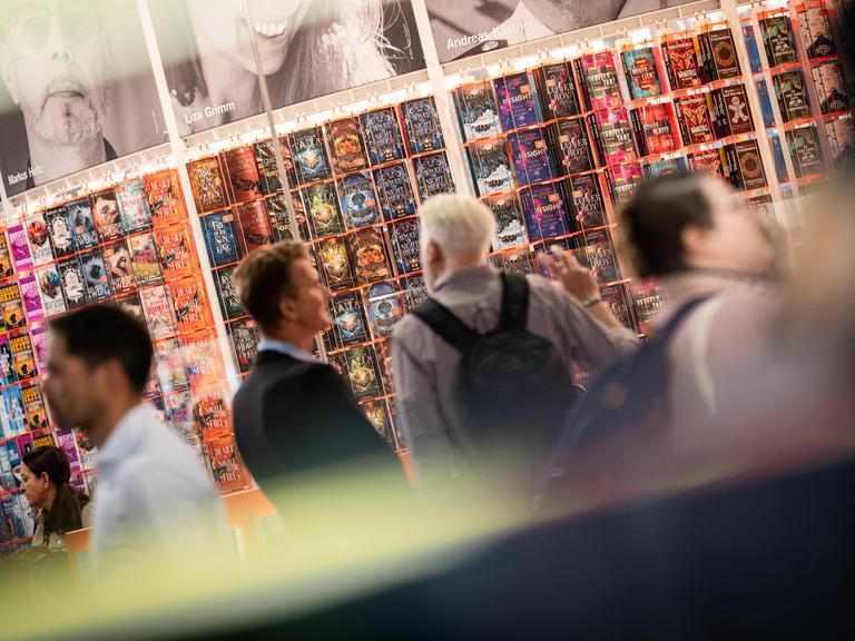 Besucher schauen sich auf der Frankfurter Buchmesse Buchtitel und die Stände der Aussteller an. 