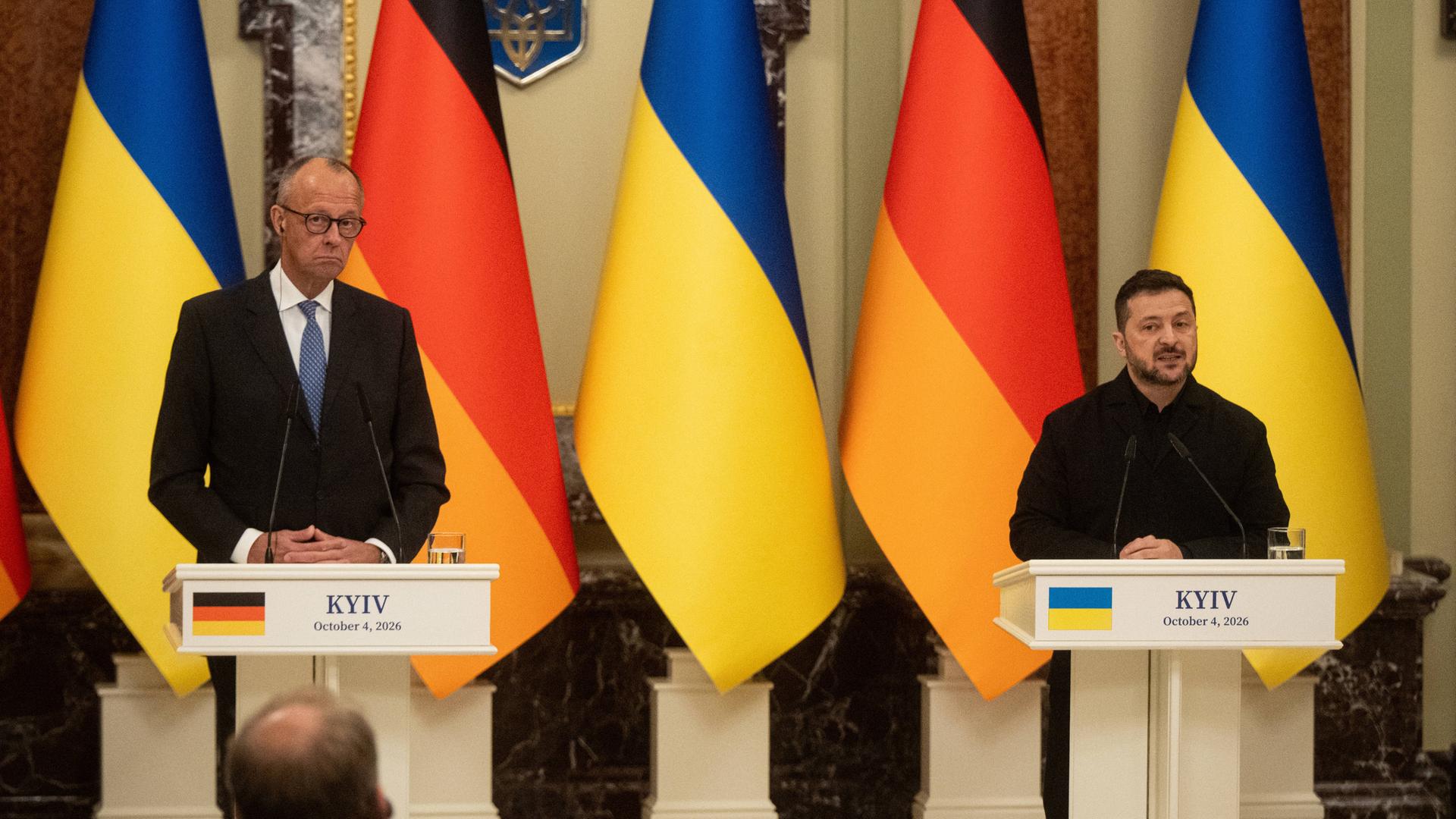 Bundeskanzler Merz und der ukrainische Präsident Selenskyj stehen nebeneinander an Rednerpulten.