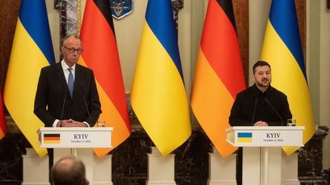 Bundeskanzler Merz und der ukrainische Präsident Selenskyj stehen nebeneinander an Rednerpulten.