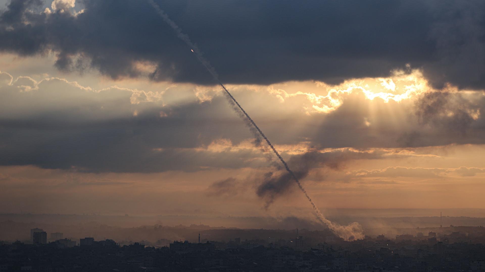 Eine Rakete an einem wolkigen Himmel, durch den sich die Sonne bricht.