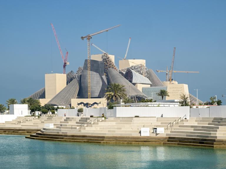 Die moderne geometrische Struktur des im Bau befindlichen Guggenheim Museums mit Kränen und Gerüsten, Abu Dhabi, 