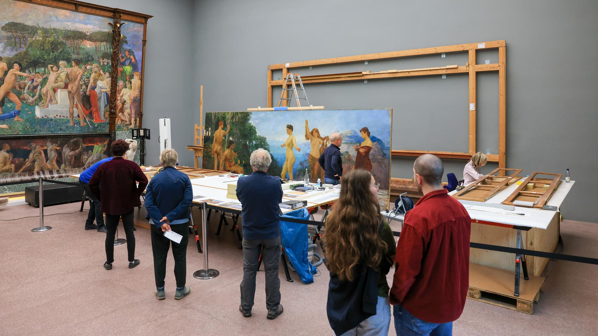 Das Klinger-Gemälde "Das Urteil des Paris" wird im Museum der bildenden Künste in Leipzig öffentlich restauriert. Man sieht das Bild in einer Werkstatt. Besucher betrachten es.