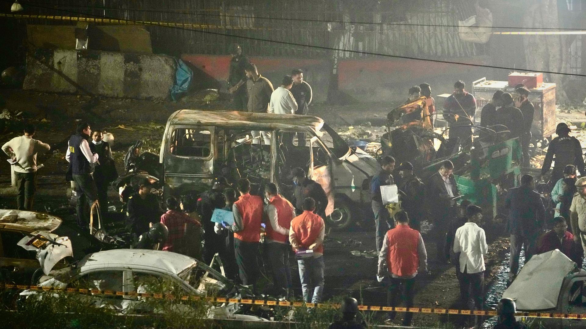 Sicherheitsbeamte inspizieren beschädigte Fahrzeuge nach einer Autoexplosion in der Nähe des historischen Red Fort in Neu-Delhi.