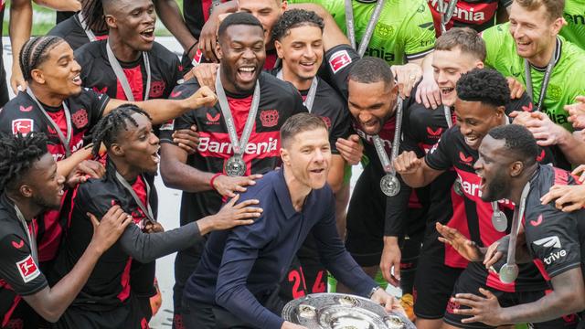 Der Trainer und die Spieler von Bayer Leverkusen feiern mit der Meister-Schale. 