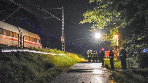 Einsatzkräfte an der Bahnlinie bei dem entgleisten ICE-Zug