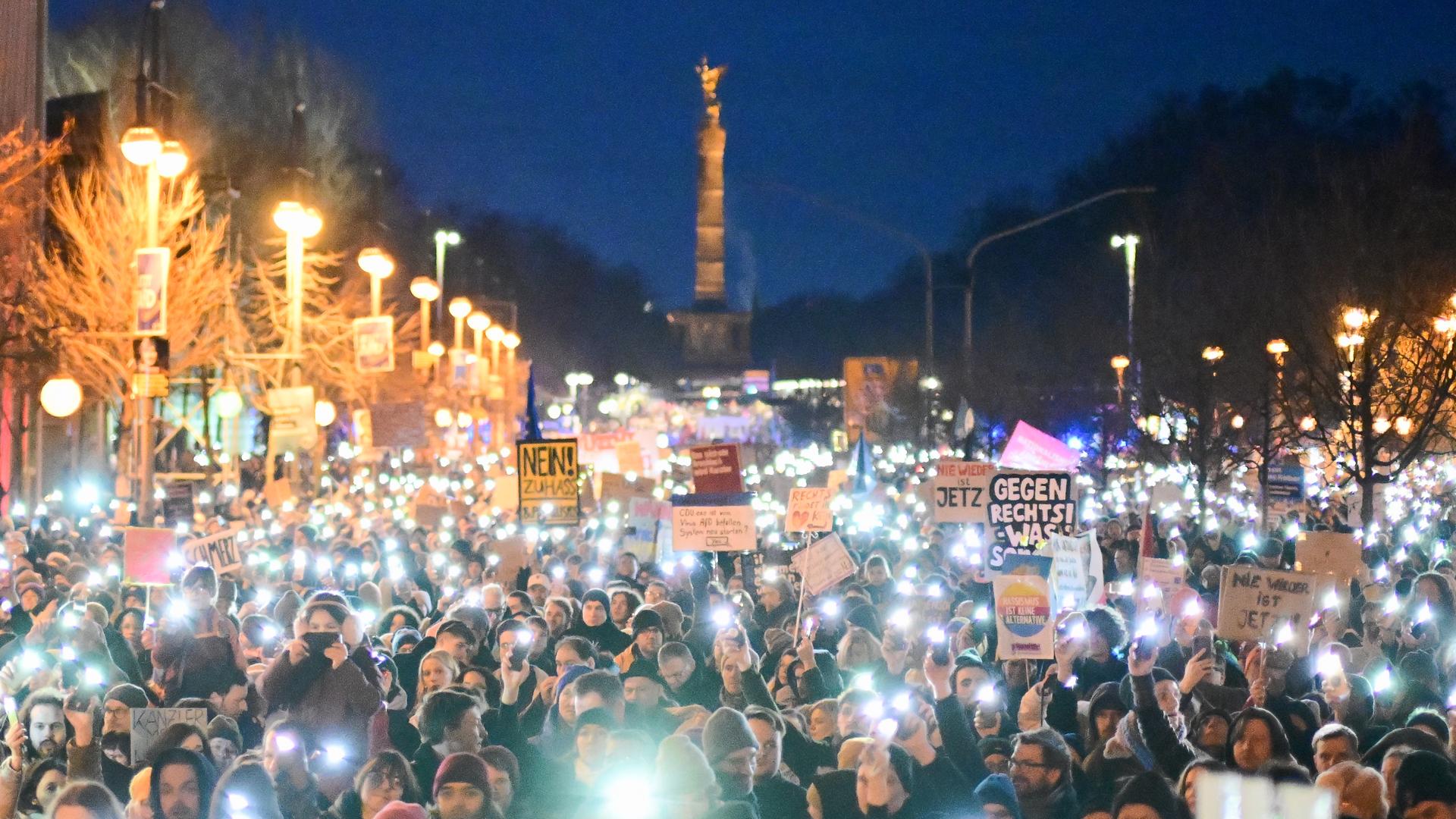 Menschen halten während einer Demonstration unter dem Motto "Aufstand der Anständigen" auf der Straße vor der CDU-Parteizentrale Lichter hoch - im Hintergrund ist die Siegessäule zu sehen. 