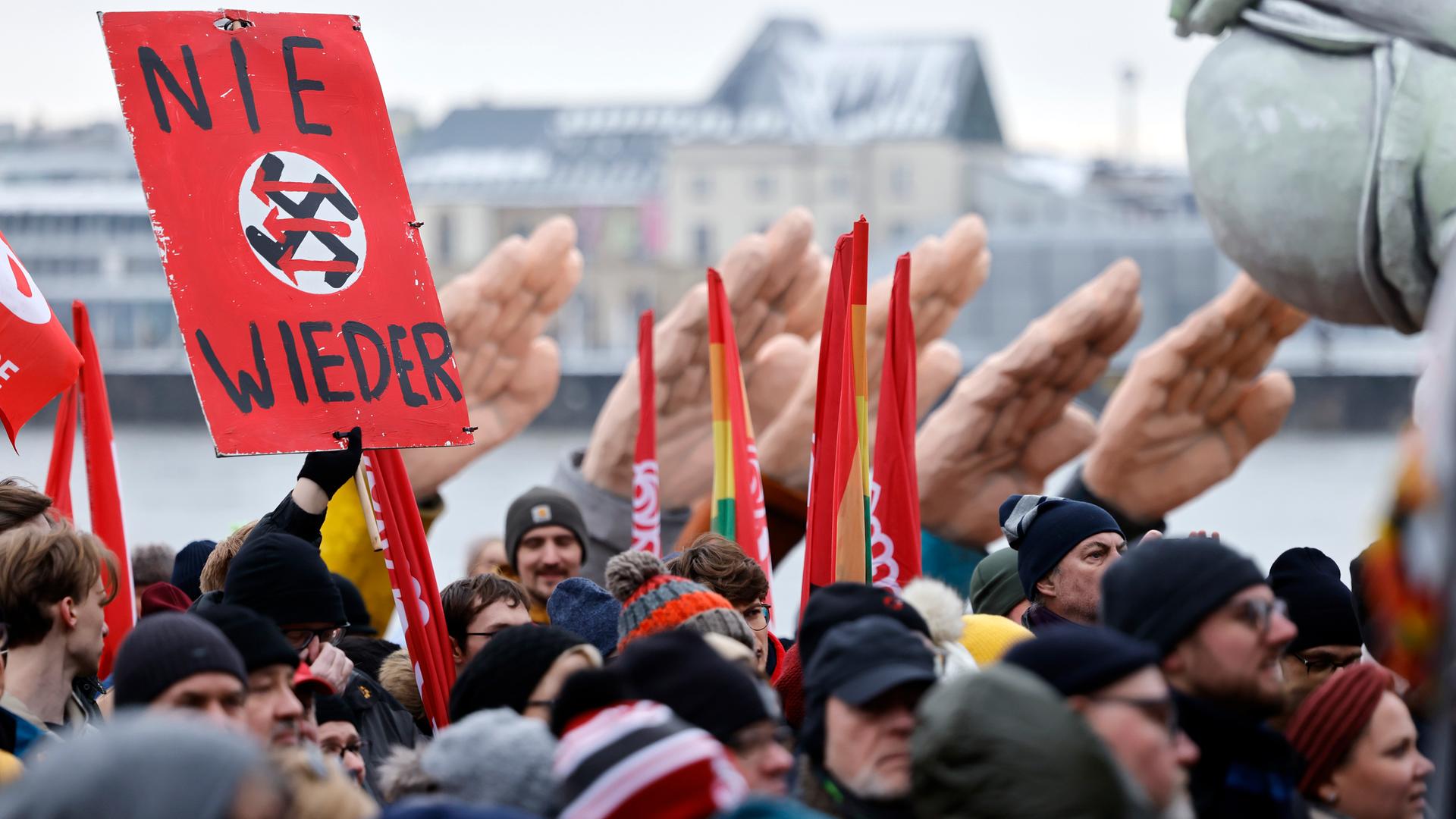 Karnevalswagen mit zum Hitlergruß erhobenen Händen, ein Schild mit "Nie wieder"-Aufschrift auf der Demo des Bündnisses 'Köln stellt sich quer' gegen Rechtsextremismus am 21.01.2024.