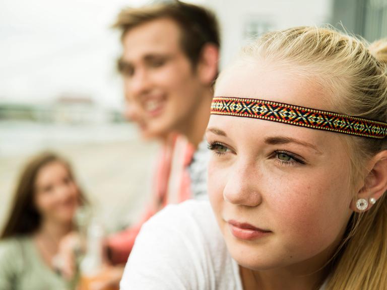 Blondes Mädchen mit Stirnband schaut zur Seite