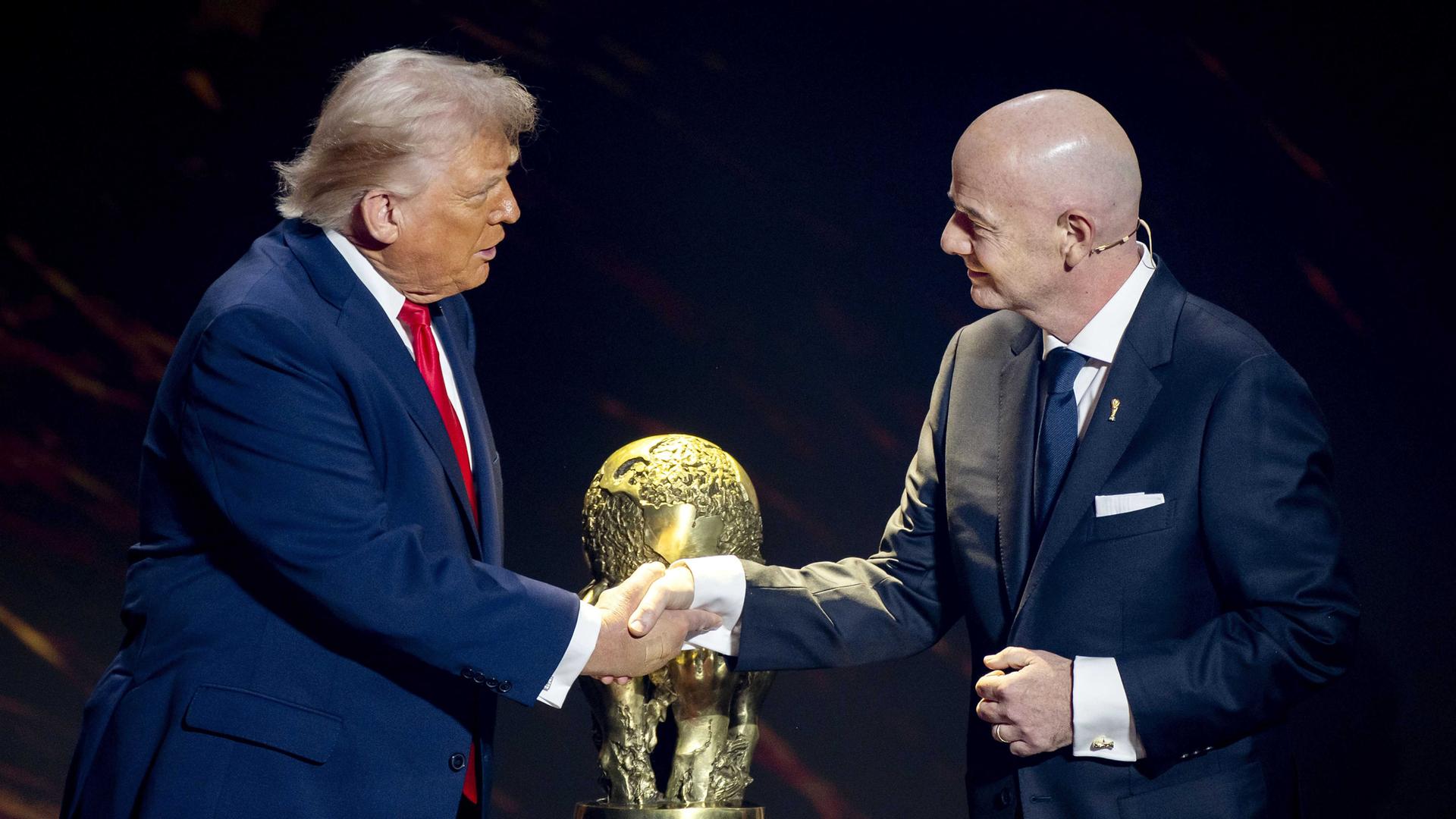US-Präsident Donald Trump und FIFA-Präsident Gianni Infantino schütteln sich vor dem WM-Pokal die Hände.