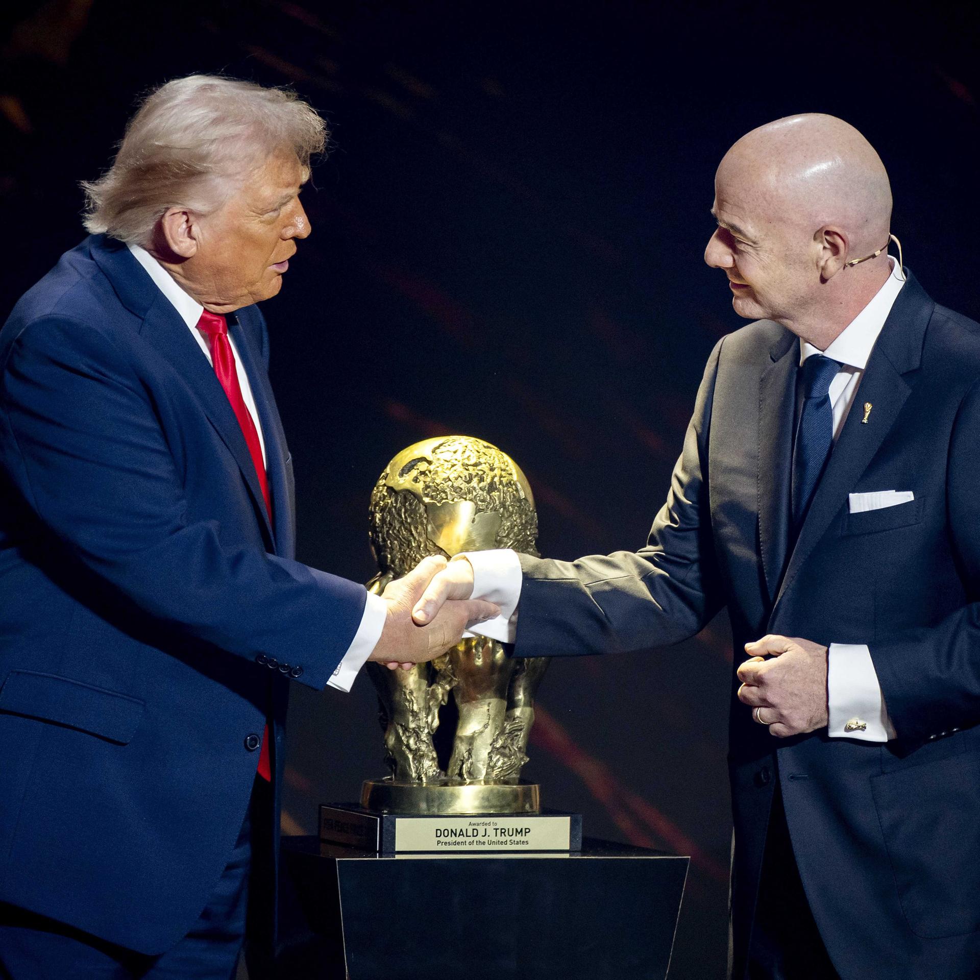 US-Präsident Donald Trump und FIFA-Präsident Gianni Infantino schütteln sich vor dem WM-Pokal die Hände.