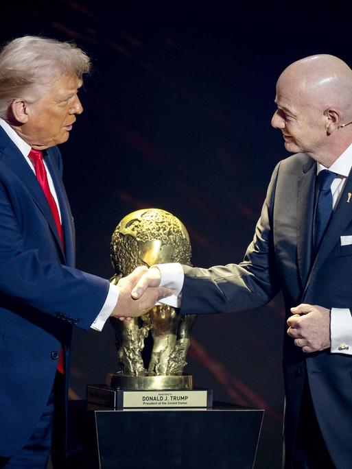 US-Präsident Donald Trump und FIFA-Präsident Gianni Infantino schütteln sich vor dem WM-Pokal die Hände.