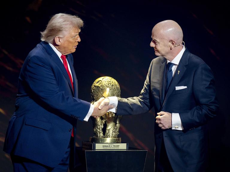 US-Präsident Donald Trump und FIFA-Präsident Gianni Infantino schütteln sich vor dem WM-Pokal die Hände.