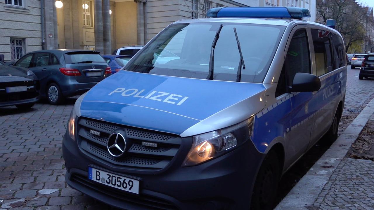 Ein Polizeiauto steht vor einer Berliner Schule. Ein Polizeiauto steht vor einer Berliner Schule.