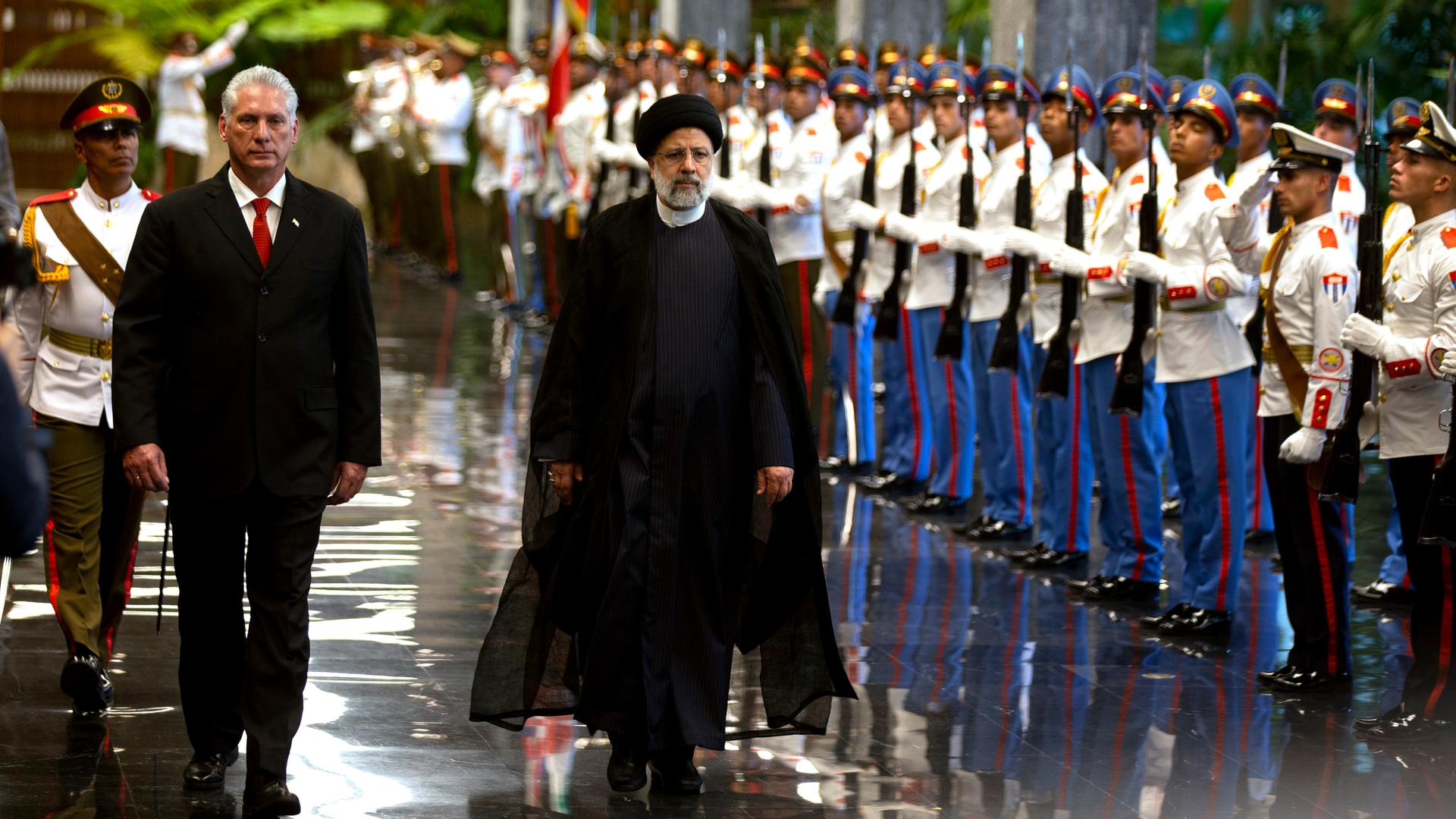 Miguel Diaz-Canel, Präsident von Kuba, und Ebrahim Raisi, Präsident des Iran, gehen an einer Ehrengarde vorbei.