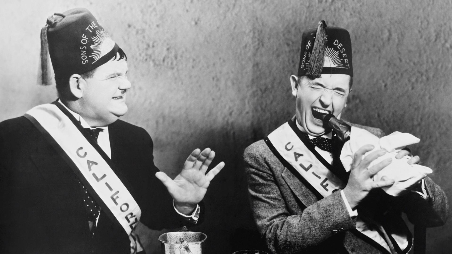 Chaotische Szenerie an einem Esstisch mit den Komikern Oliver Hardy und Stan Laurel