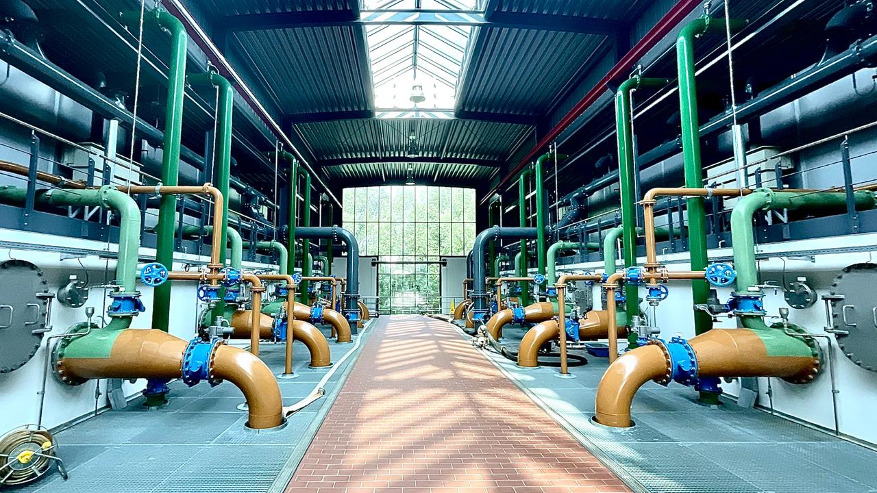Blick in eine Halle mit braunen und grünen Leitungen und Rohren