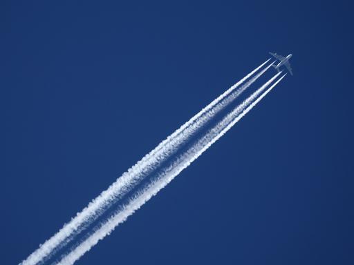 Ein Flugzeug der Qatar Airline hinterlässt am wolkenlosen Himmel Kondensstreifen.