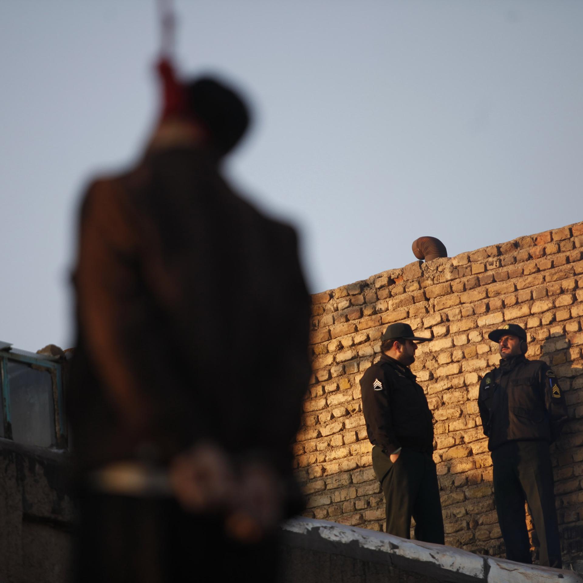 Unscharf zu erkennen, wie ein Mann an einem Seil hängt. 