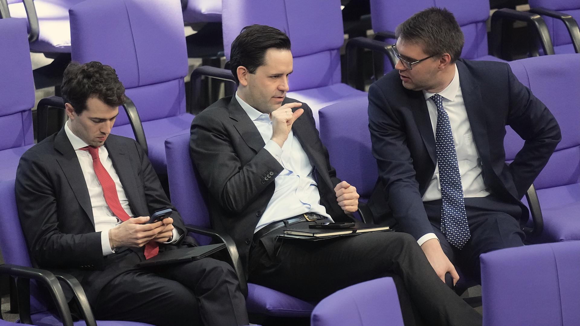 Carl-Philipp Sassenrath, Johannes Winkel und Sebastian Schmidt - alle drei Mitglieder der Jungen Gruppe der Union, sitzen in der Debatte zum Bundeshaushalt im Bundestag.