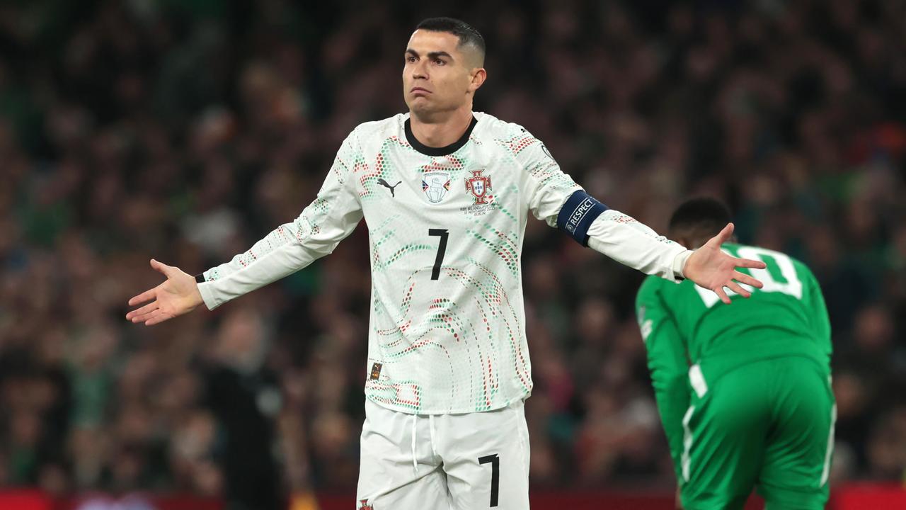 Ronaldo hebt unschuldig die Hände in die Höhe. Hinter ihm in Rückenansicht ein irischer Spieler.