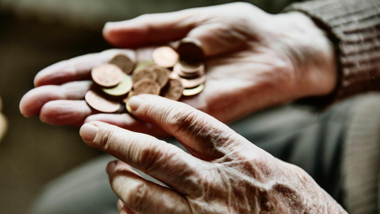 Die Hände einer alten Frau zählen Centmünzen ab