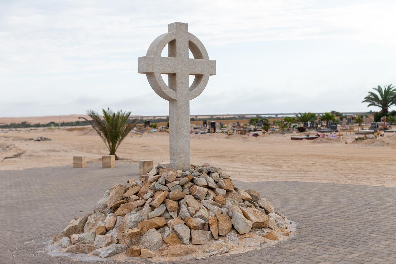 Ein steinernes Kreuz steht auf einem Steinhaufen auf dem Gelände einer Gedenkstätte für die Opfer deutsche Konzentrationslager in Swakopmund.
