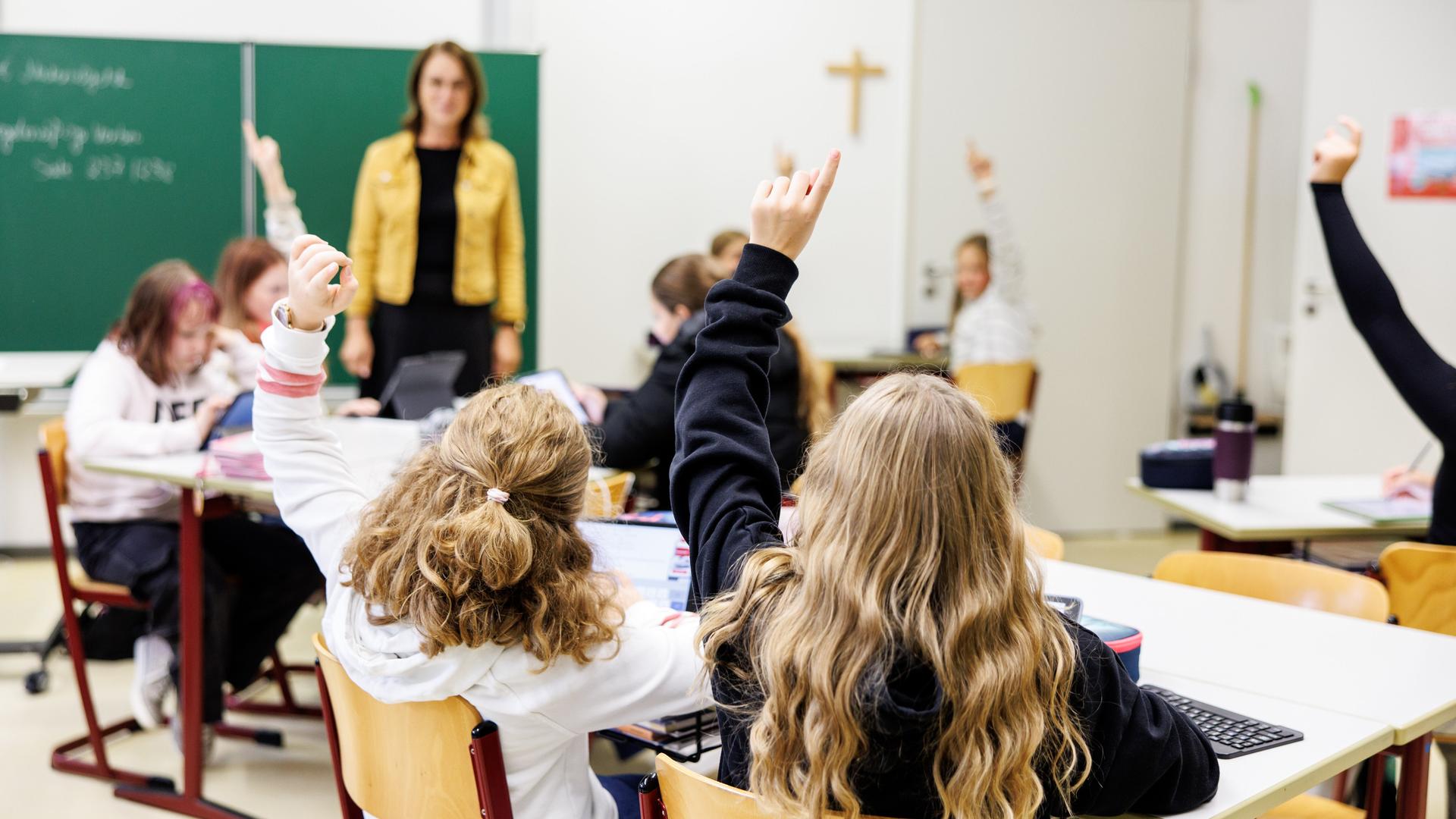 Schülerinnen einer sechsten Klasse melden sich in einem Klassenraum an der Maria-Ward-Realschule in Schrobenhausen (Bayern) während einer Unterrichtsstunde.