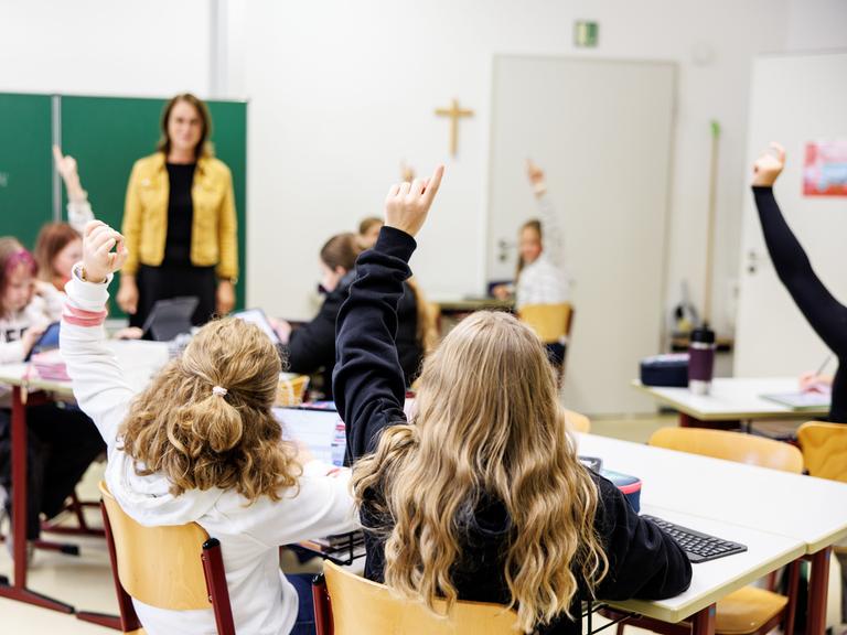 Schülerinnen einer sechsten Klasse melden sich in einem Klassenraum an der Maria-Ward-Realschule in Schrobenhausen (Bayern) während einer Unterrichtsstunde.