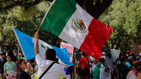 Demonstranten versammeln sich am 8. Juni 2025 im Ervan Chew Park in Houston, Texas, zu einer Demonstration gegen Trumps Einwanderungspolitik und Massenabschiebungen. Ein Demonstrant schwenkt die mexikanische Flagge.