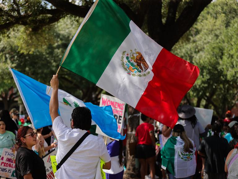 Demonstranten versammeln sich am 8. Juni 2025 im Ervan Chew Park in Houston, Texas, zu einer Demonstration gegen Trumps Einwanderungspolitik und Massenabschiebungen. Ein Demonstrant schwenkt die mexikanische Flagge.