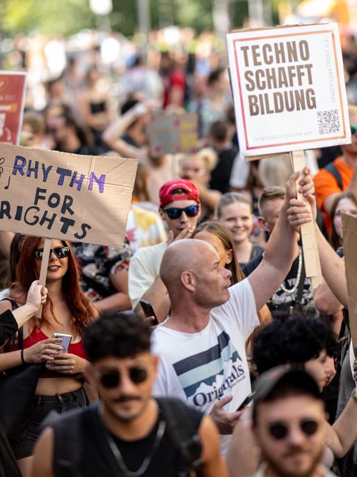 Viele Menschen nehmen an der Technoparade "Zug der Liebe" - Demonstration für Toleranz, Vielfalt und Miteinander mit Schildern mit der Aufschrift "Rythm for Rights" und "Techno schafft Bildung" teil.