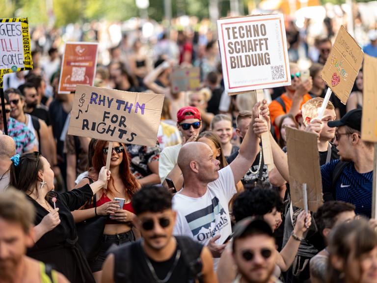 Viele Menschen nehmen an der Technoparade "Zug der Liebe" - Demonstration für Toleranz, Vielfalt und Miteinander mit Schildern mit der Aufschrift "Rythm for Rights" und "Techno schafft Bildung" teil.