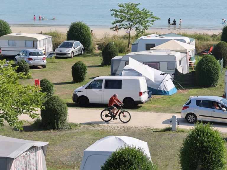 Städtischer Campingplatz mit Zelten und Wohnmobilen am Ende der Bucht von Locquirec in der Bretagne direkt am Strand. 