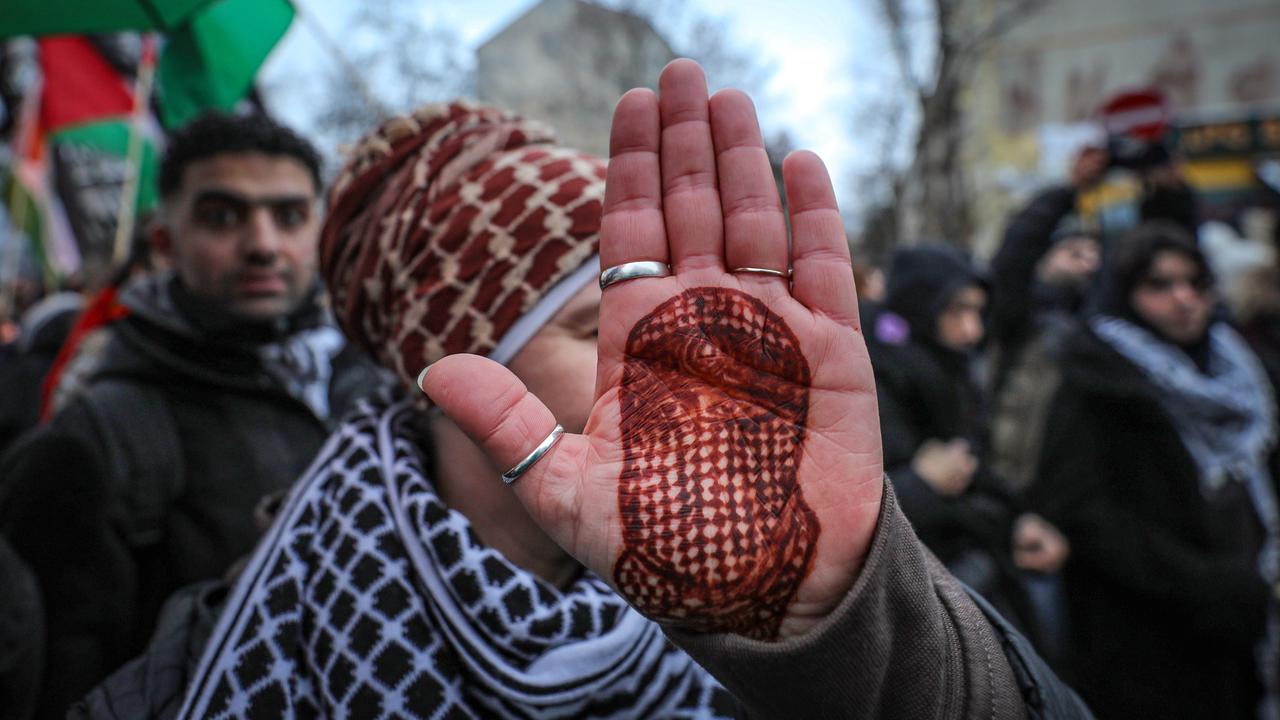Eine Demonstrantin hält ihre Handfläche in die Kamera, auf die mit Henna das Porträt des toten Hamas-Sprechers Abu Obaida gezeichnet ist.