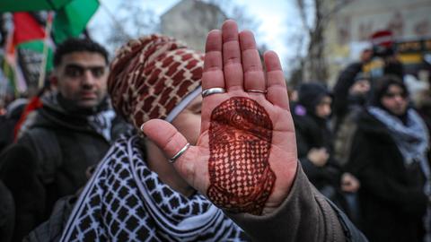 Eine Demonstrantin hält ihre Handfläche in die Kamera, auf die mit Henna das Porträt des toten Hamas-Sprechers Abu Obaida gezeichnet ist.