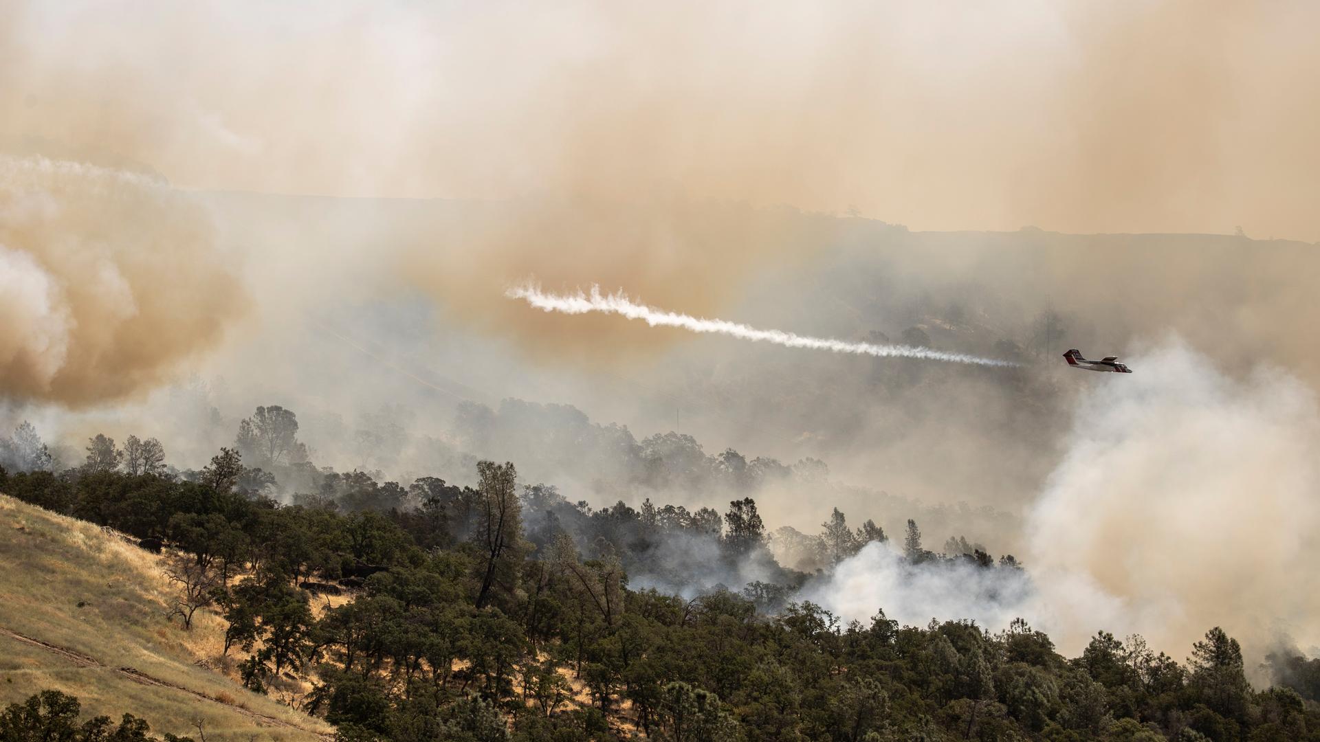 Oroville: Ein Lufttransportflugzeug vom Typ Cal Fire OV-10 wirft Feuerlöschmittel über einem Feuer ab. Oroville: Ein Lufttransportflugzeug vom Typ Cal Fire OV-10 wirft Feuerlöschmittel über einem Feuer ab.