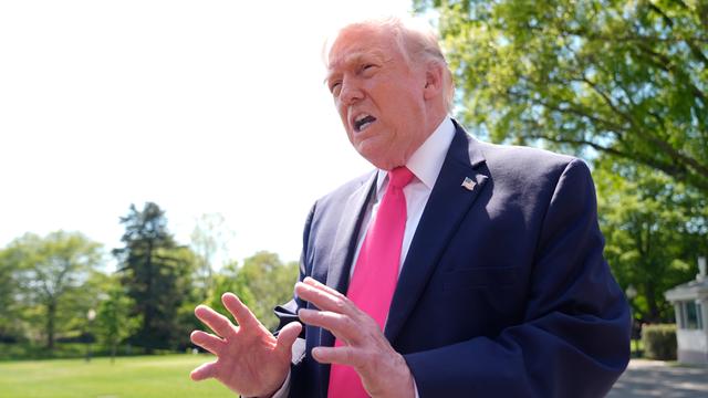 Donald Trump steht auf dem Rasen hinter dem Weißen Haus und gestikuliert.